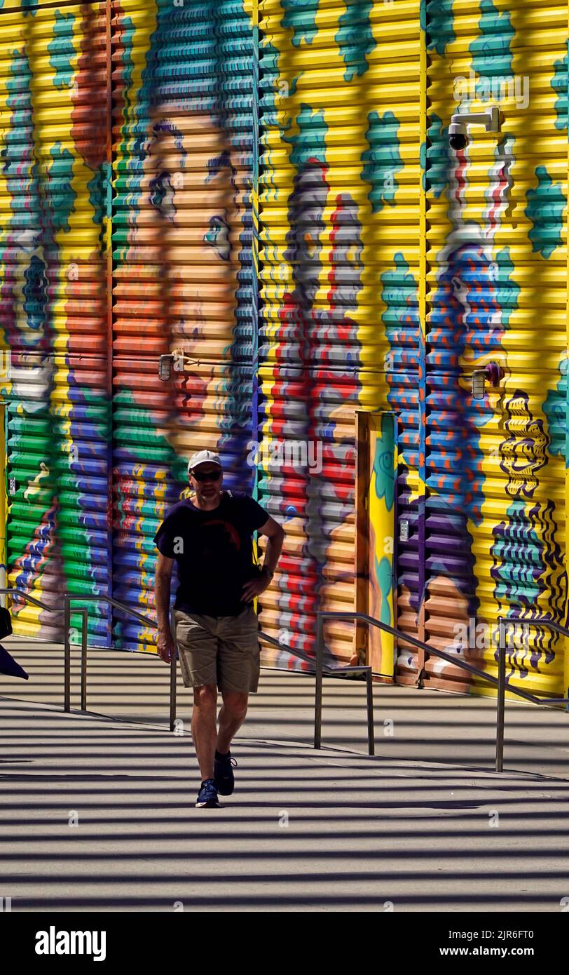 Gente caminando delante de un gran mural público en el centro financiero mundial en el centro de Manhattan NYC Foto de stock