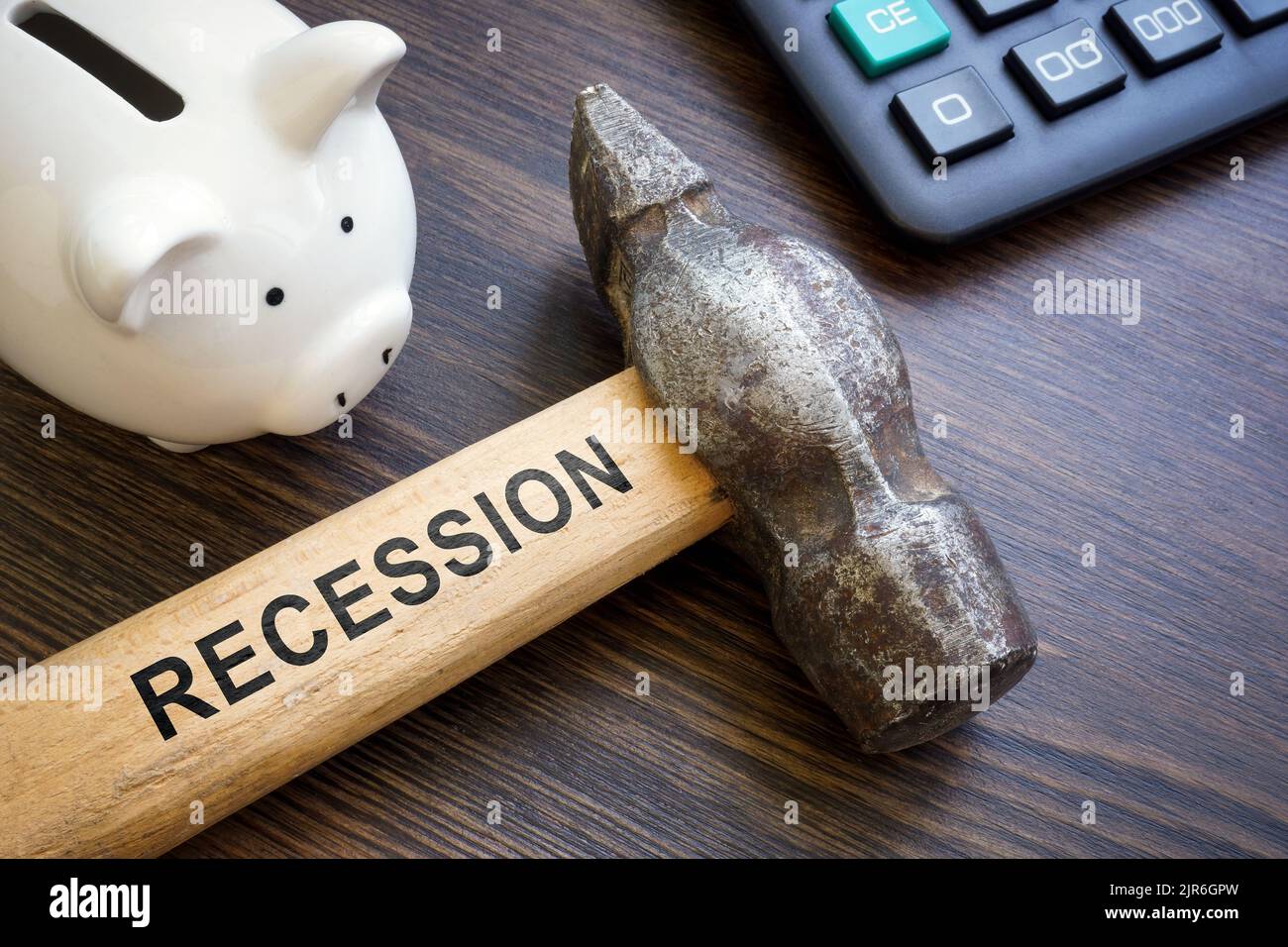 Banco de cerdos para los ahorros y martillo con la palabra recesión. Foto de stock