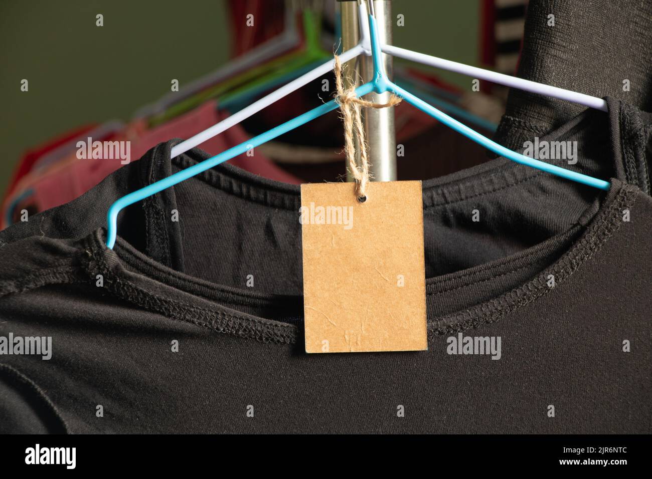 cartón, embalaje, casual, ropa, marca, compras, el papel marrón etiqueta de precio pesa en la ropa en un estante en una percha en el área de ventas, pri en blanco Foto de stock