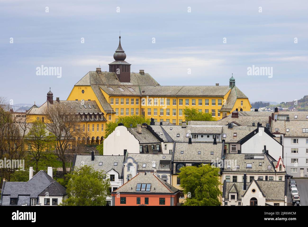 La histórica y amarilla escuela Aspøy, Skole y tejados de Alesund, Noruega Foto de stock