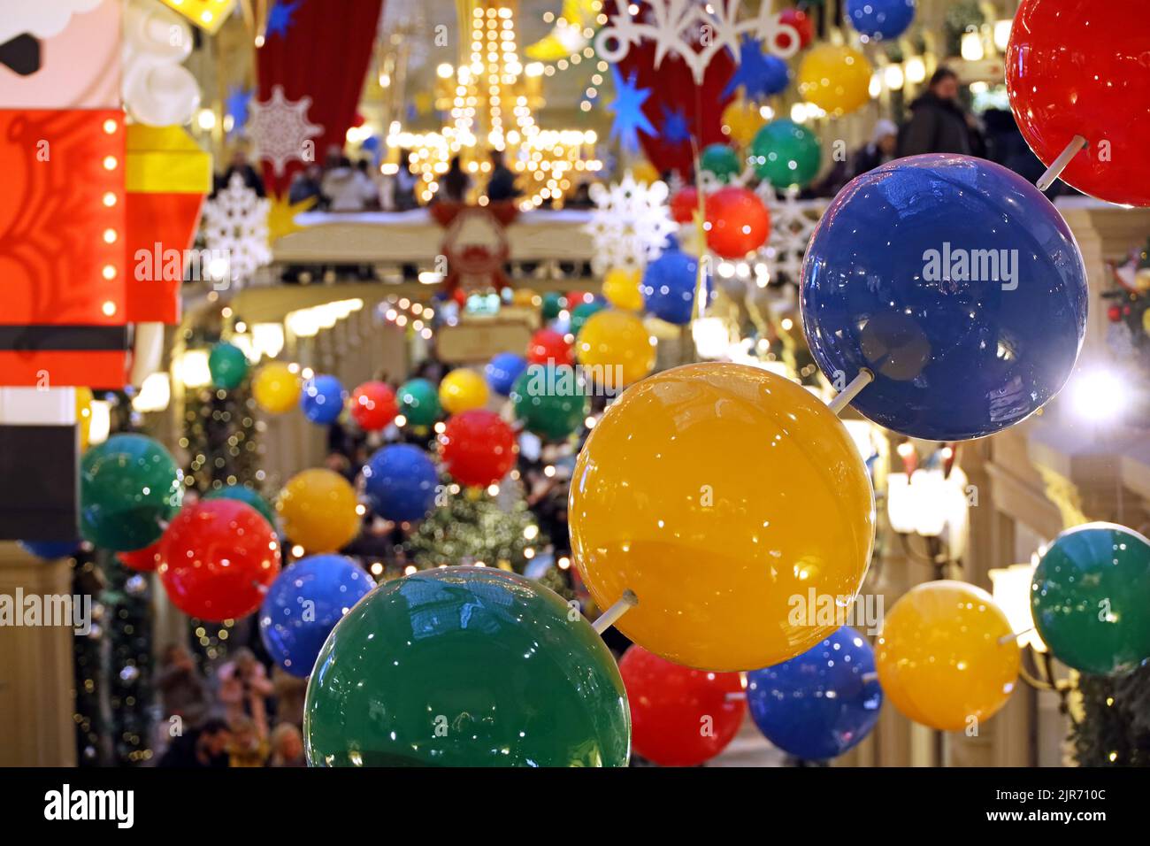 Decoraciones navideñas en el centro comercial. Vista desenfocada a luces festivas y gente caminando Foto de stock