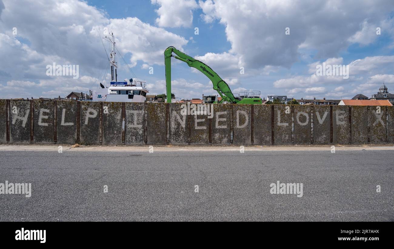 'Ayuda, necesito amor' Mural en la pared del puerto en el Puerto de Great Yarmouth, Norfolk, Inglaterra, Reino Unido. Foto de stock
