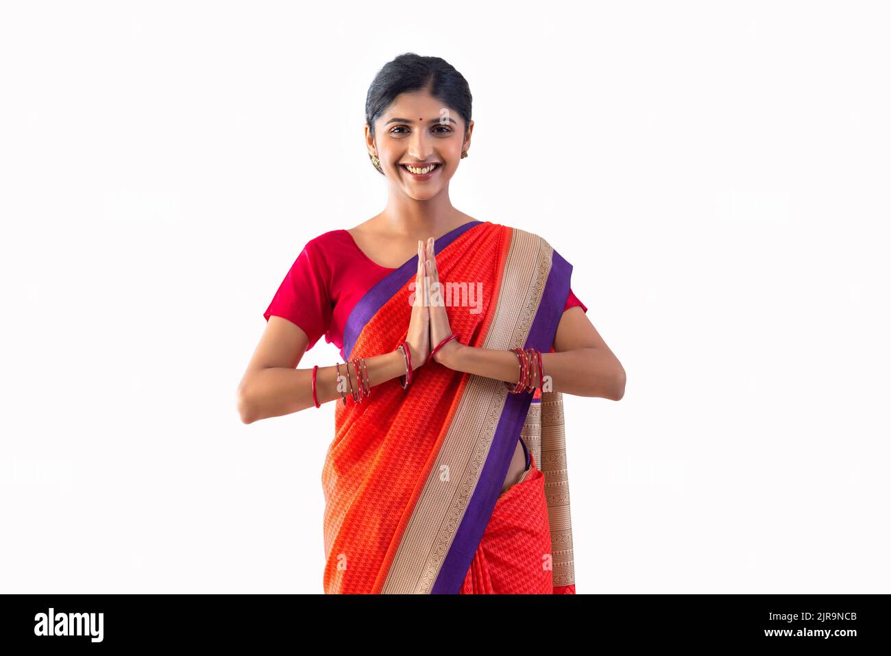 Retrato de alegre saludo de mujer con gesto namaste Foto de stock