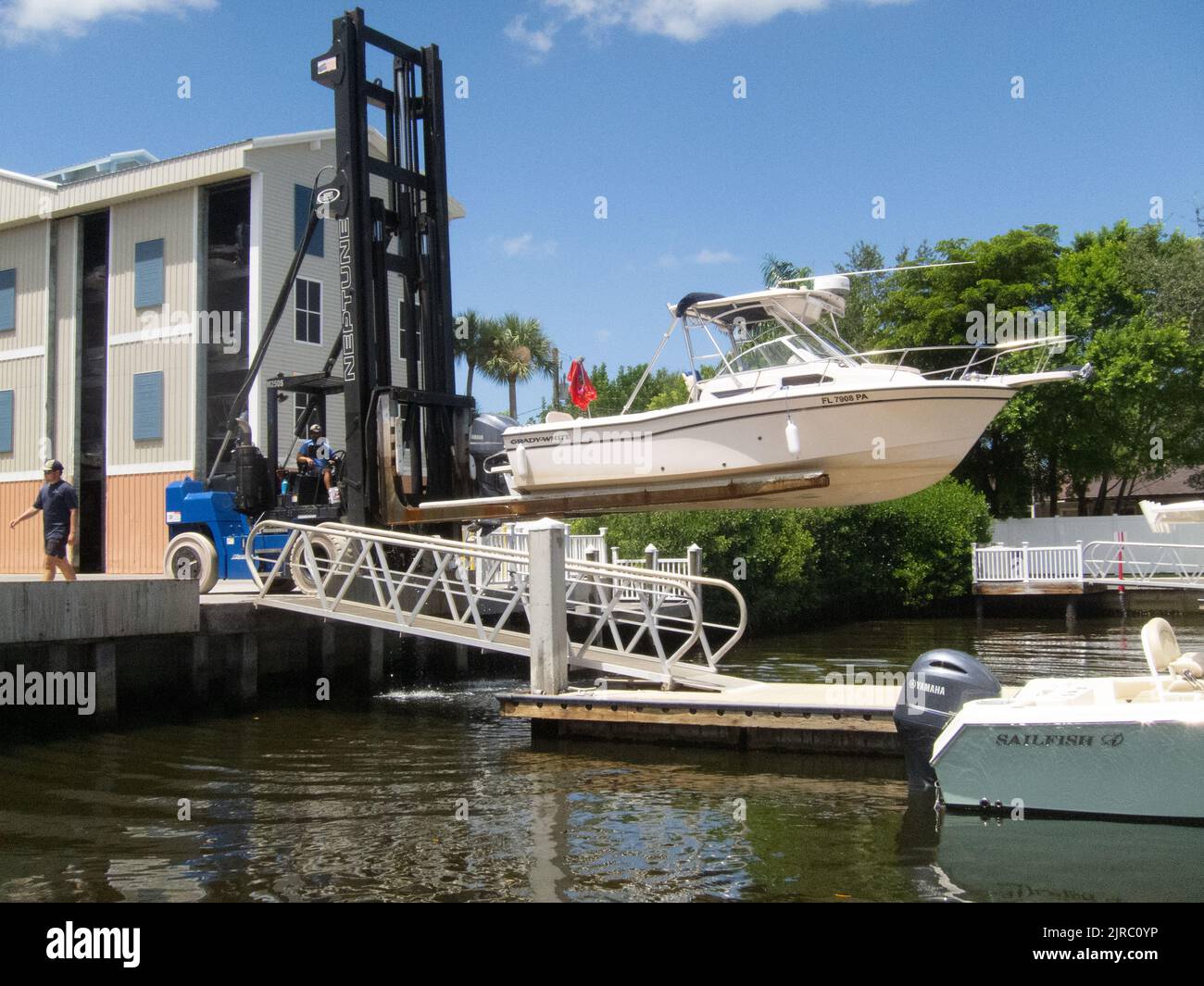 Carretilla elevadora que levanta una embarcación desde el muelle del puerto deportivo para trabajos de mantenimiento y almacenamiento. Bradenton, Florida, Estados Unidos. Foto de stock