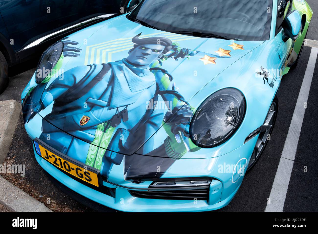 Un coche Porsche personalizado en colores y logotipo para el juego de vídeo en línea Fortnite. El capó del coche presenta un carácter fortnita Foto de stock