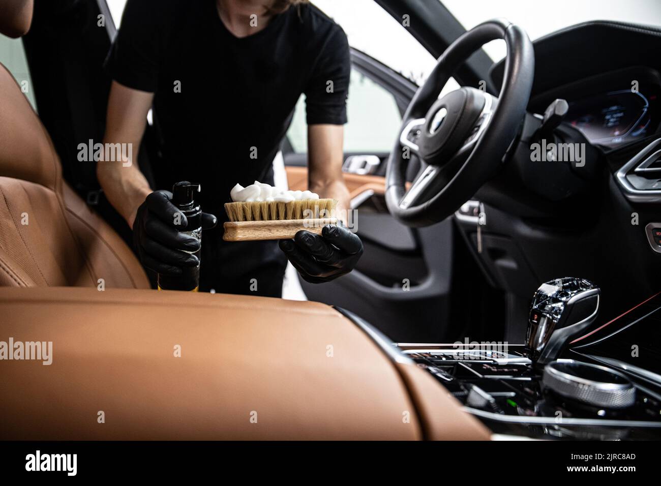 coche detallando empleado del estudio limpia la tapicería de cuero