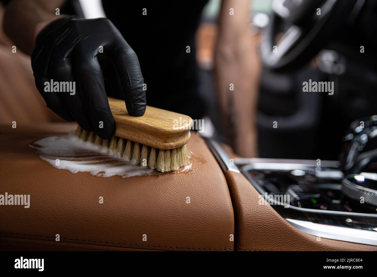 coche detallando empleado del estudio limpia la tapicería de cuero