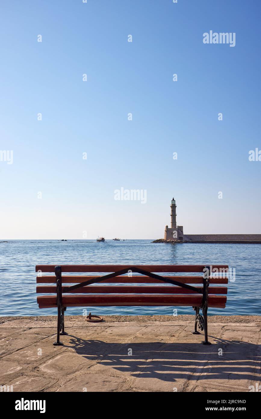 Puerto deportivo veneciano de Chania con banco y el faro en el día soleado, Chania Creta, Grecia Foto de stock