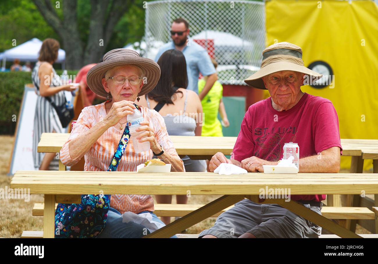 Una pareja mayor disfrutando de un almuerzo en una feria en West Barnstable, Massachusetts en Cape Cod Foto de stock