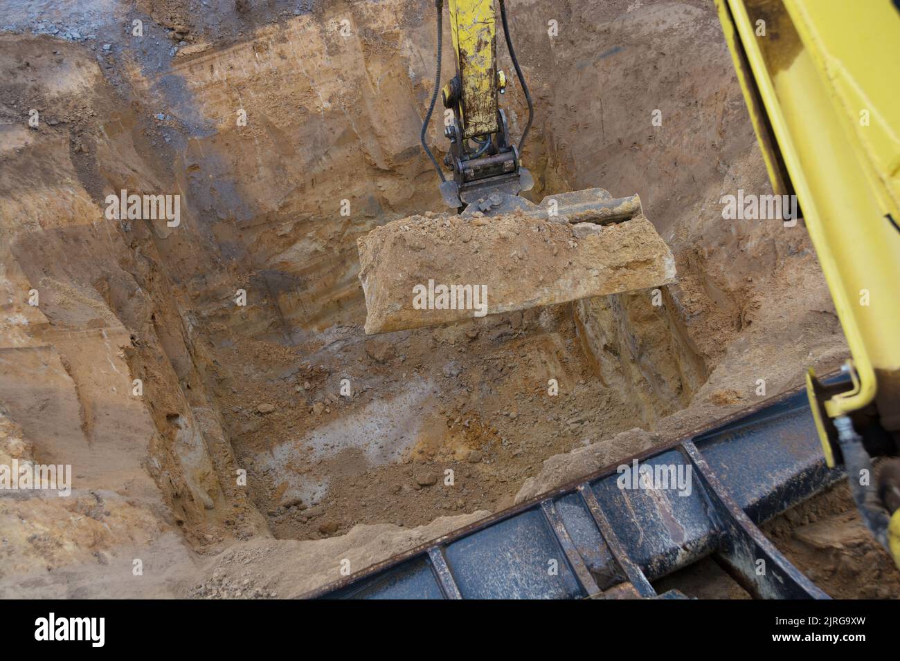Excavadora sumerge un agujero profundo para una cisterna Foto de stock