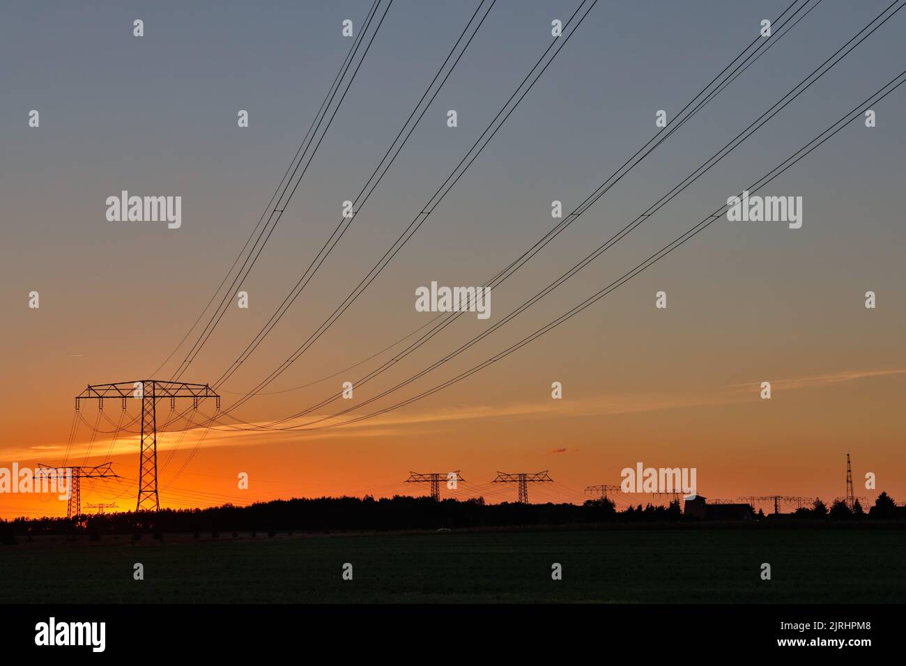 Freileitungstrasse im Sonnenuntergang Übertragung Energie Foto de stock
