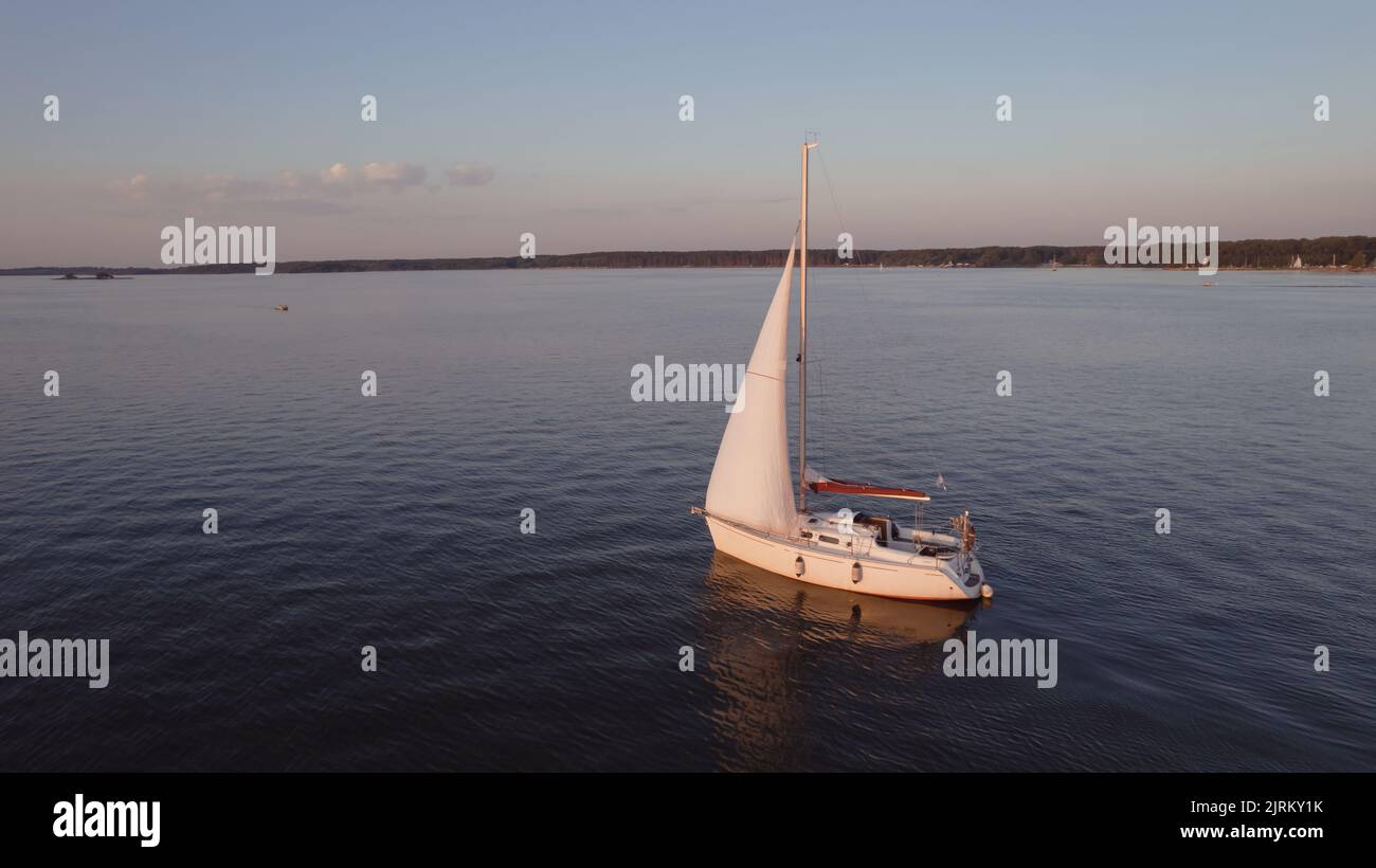 Vista aérea de un velero en un lago al atardecer Foto de stock
