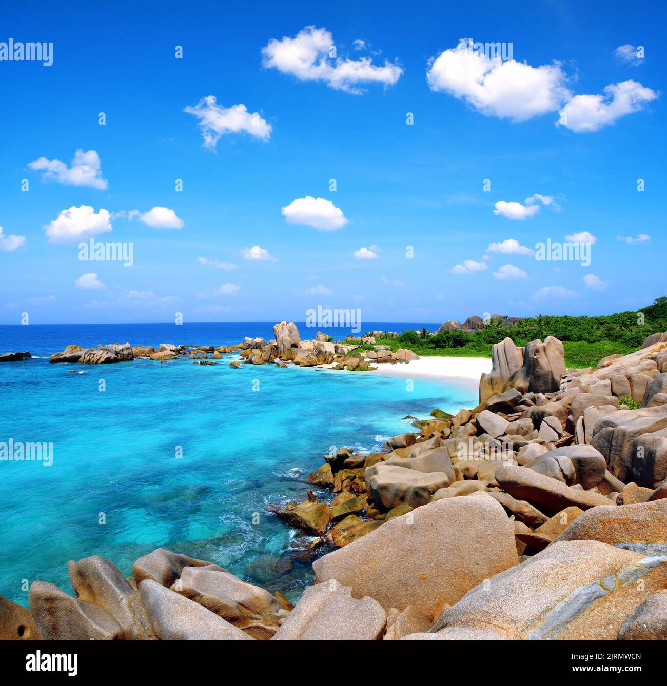 Playa Anse Marron con grandes piedras de granito en la Isla La Digue, Seychelles. Paisaje tropical con cielo soleado. Foto de stock