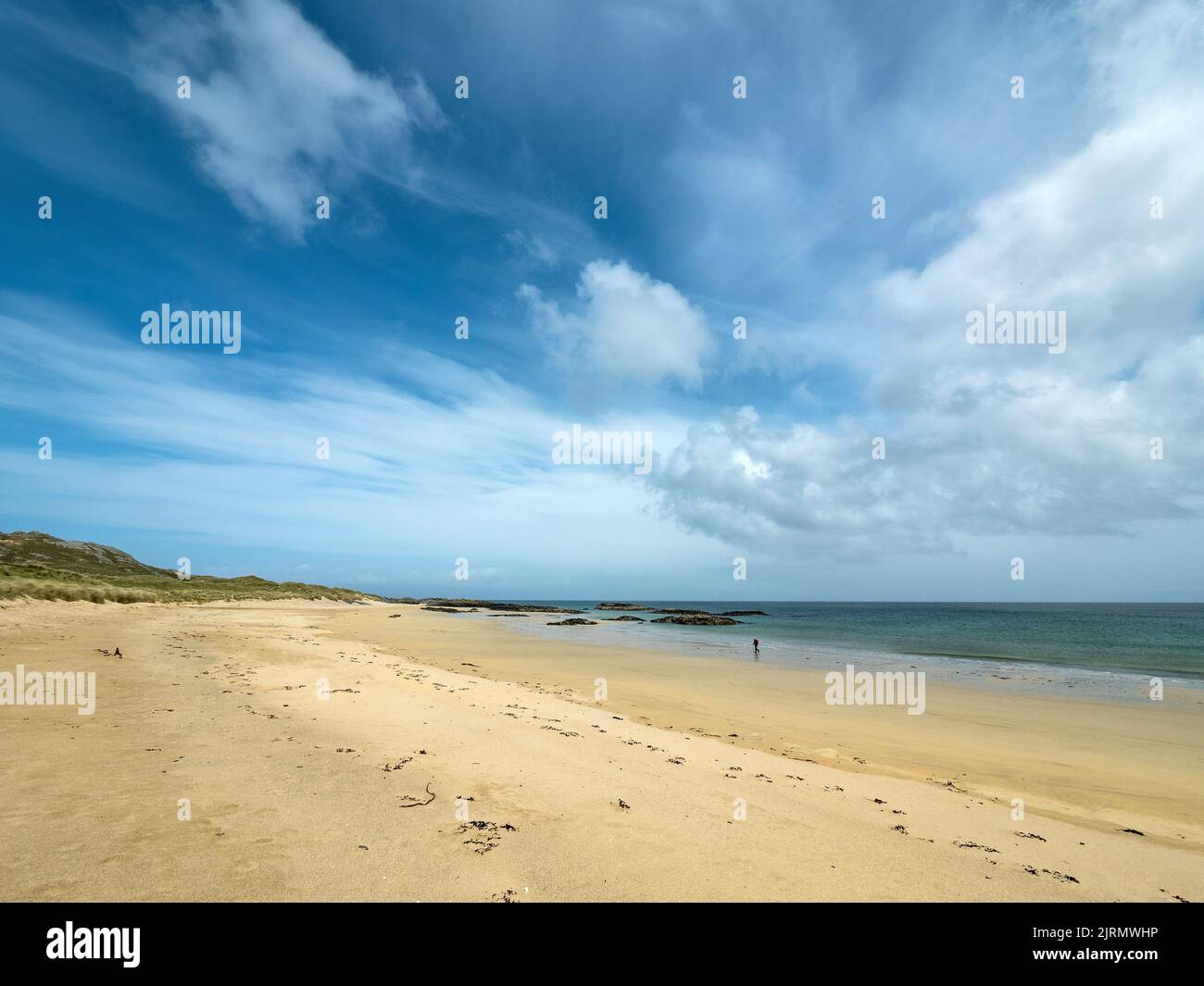 Figura solitaria en las remotas y hermosas arenas de Balnahard Beach en la Isla Hebrideana de Colonsay, Escocia, Reino Unido Foto de stock