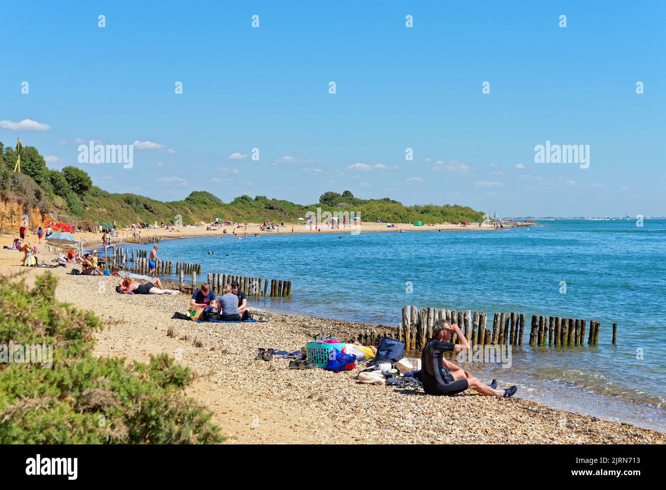 Multitudes en la playa en el parque rural de Lepe en un día caluroso y soleado de verano, Hampshire Inglaterra, Reino Unido Foto de stock