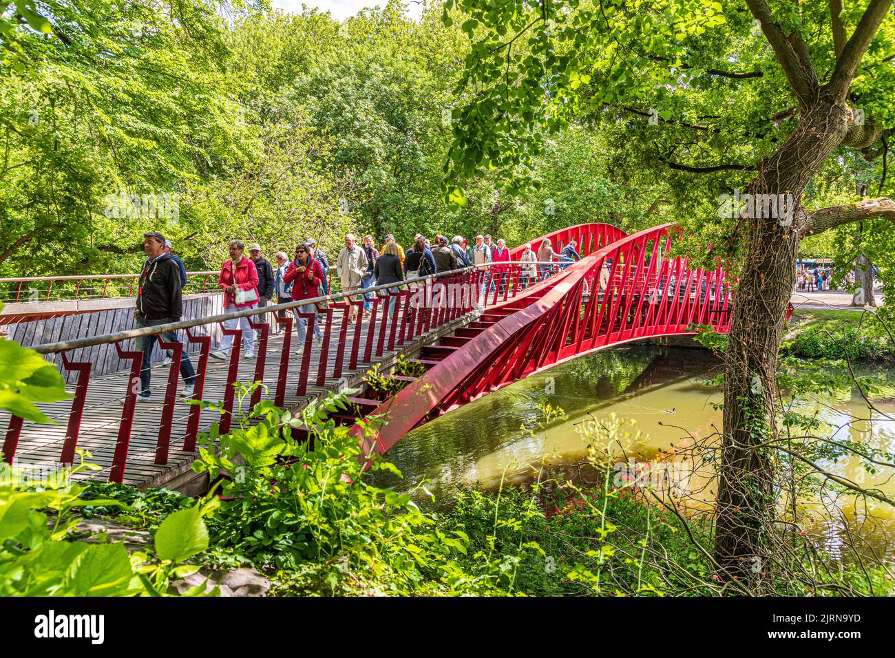 Turistas que cruzan el puente Barge (Bargebrug) que conecta el parque Minnewater con las afueras de la ciudad de Brujas, Bélgica Foto de stock