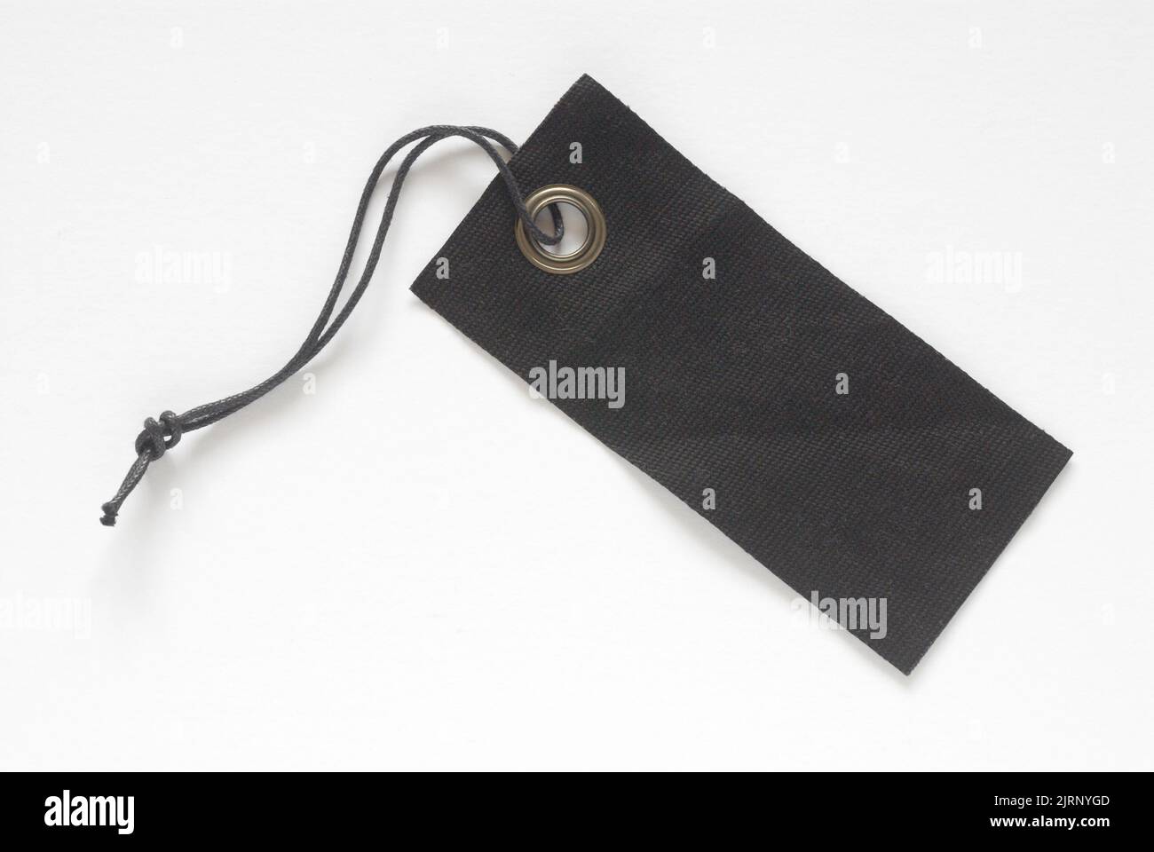 Etiqueta de tela negra con presilla de cuerda negra recortada en blanco Foto de stock