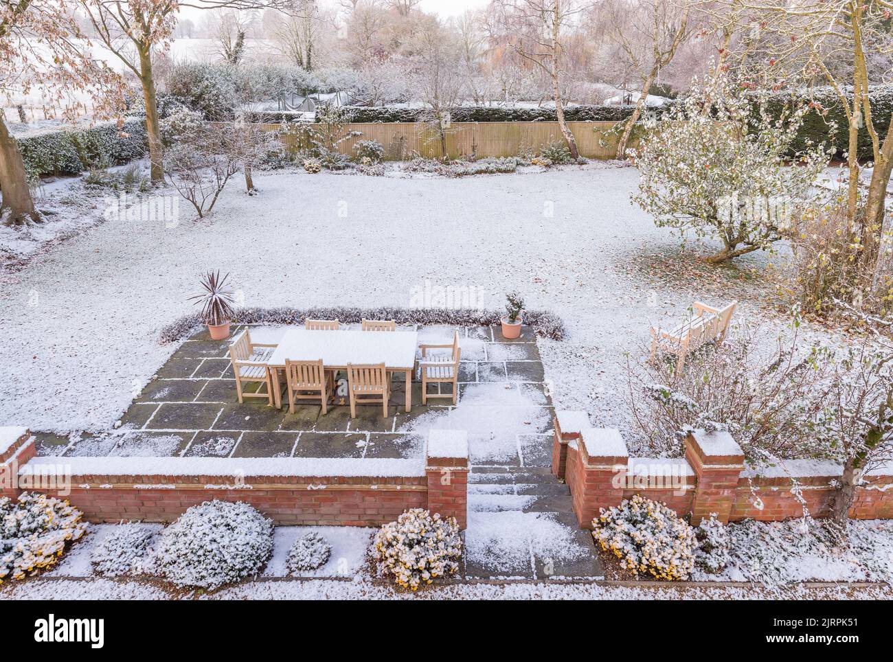 Gran jardín trasero del Reino Unido cubierto de nieve en invierno. Escena de patio nevado Foto de stock