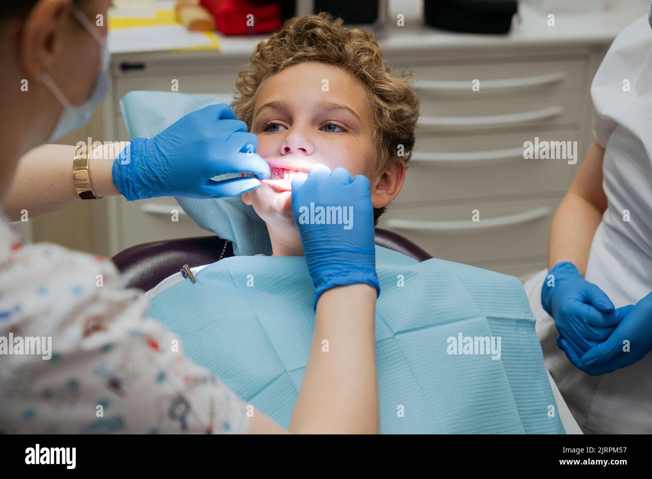 Un odontólogo de ortodoncia revisa los dientes del niño y la mordedura. Foto de stock