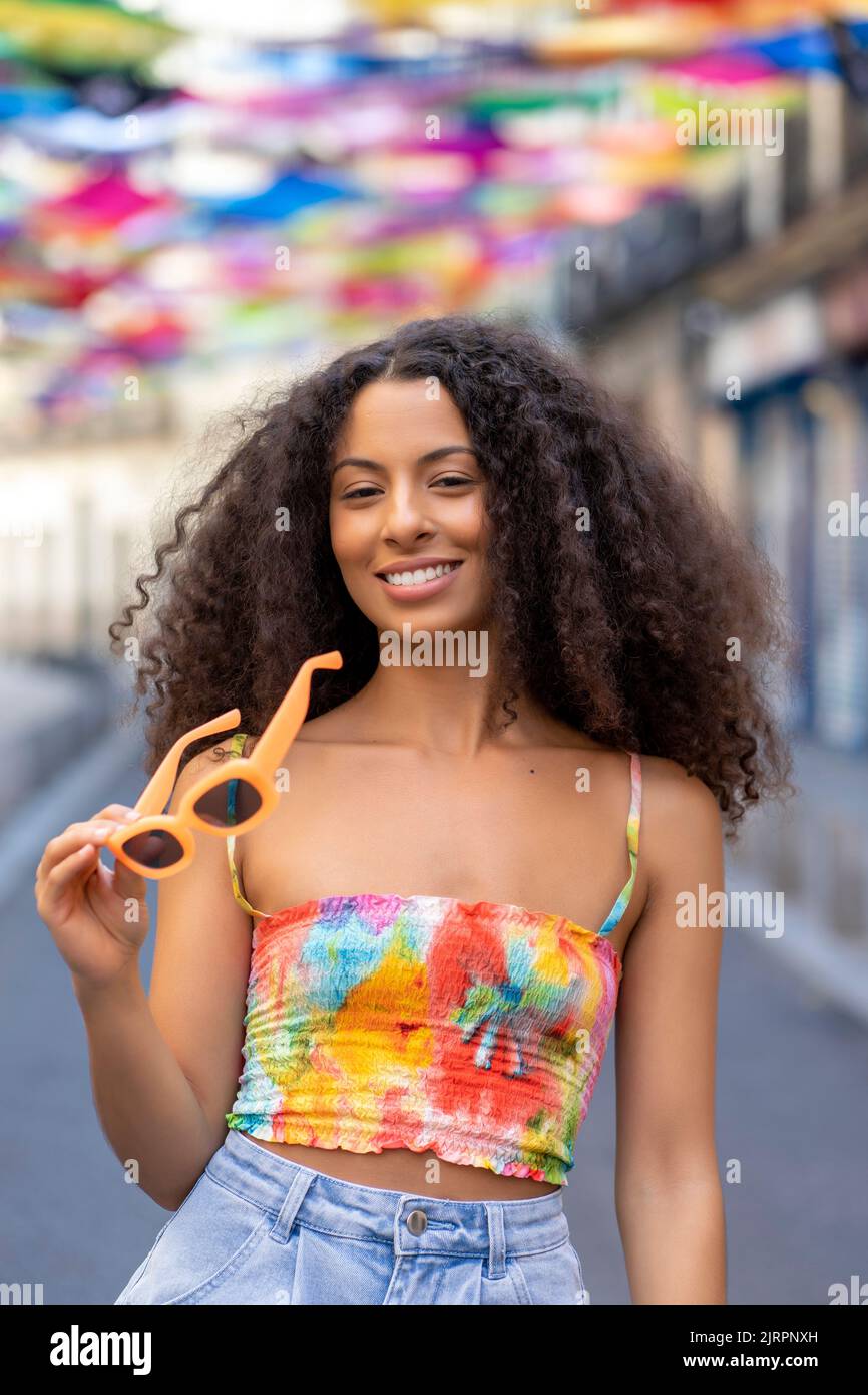 chica con pelo afro usando sus gafas de sol Foto de stock