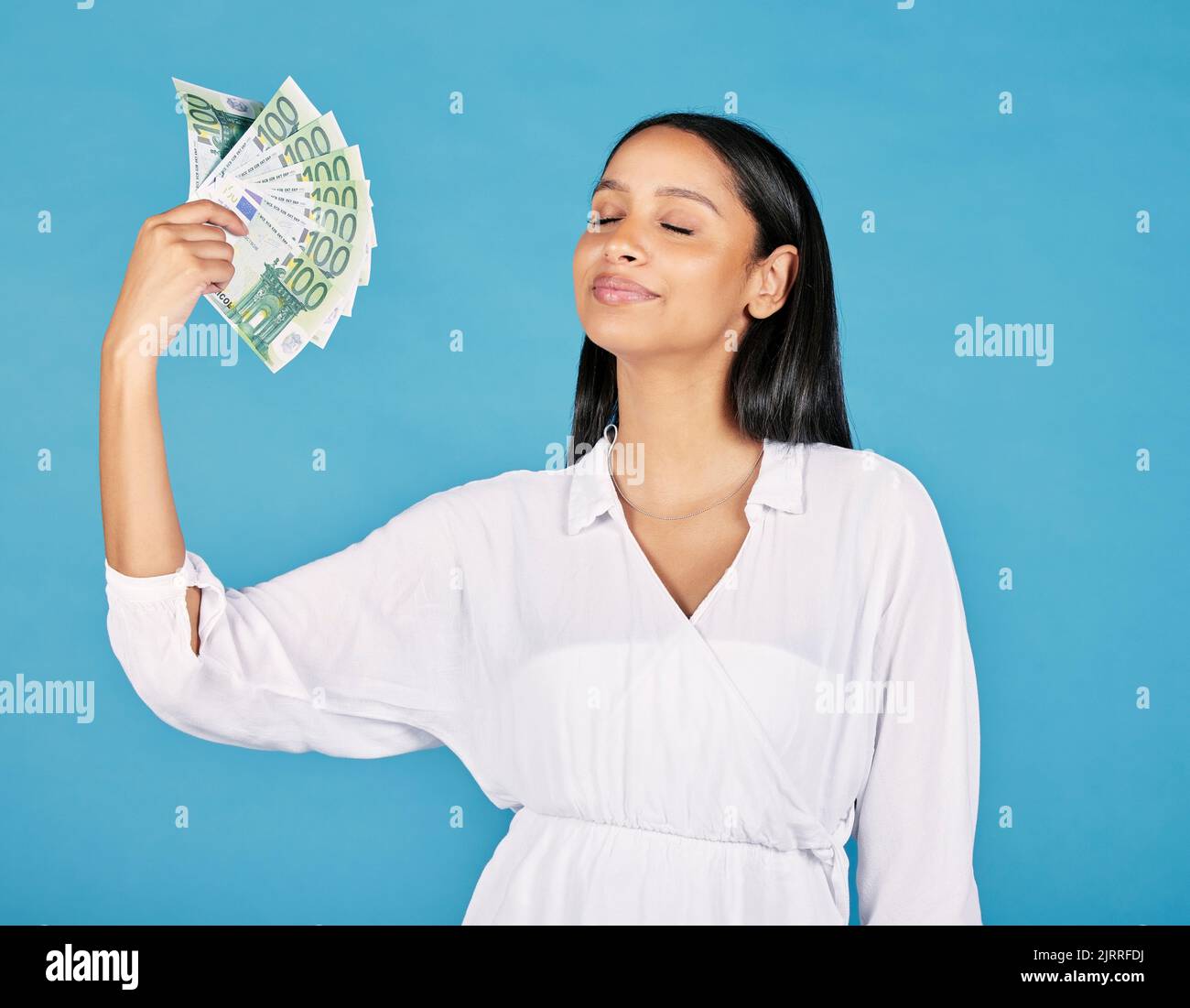 .Money, abundancia y mujer rica que sostiene ventilador del efectivo y de refrescarse ella misma, lista para soplar o para gastarlo todo. Ganadora de lotería femenina abrazando la suerte, el éxito Foto de stock