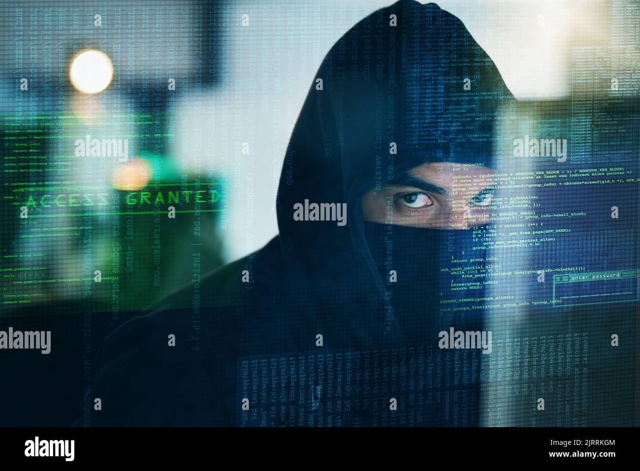 ¿Cómo lo mantendrá fuera de sus datos? Retrato de un hacker informático serio pirateando un ordenador en una oficina. Foto de stock