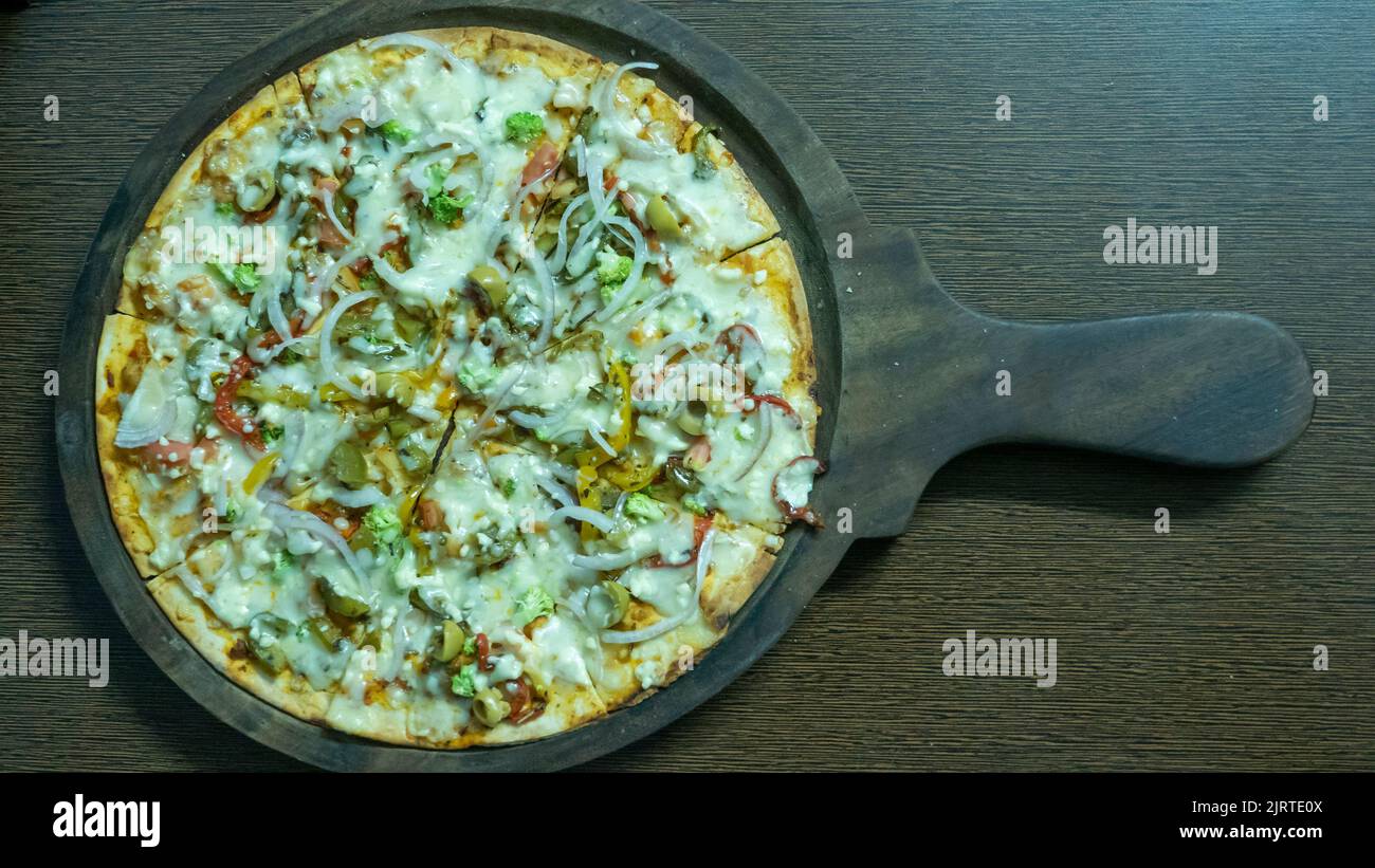 Pizza vegetariana en la india. Pizza de verduras con queso indio. Foto de stock