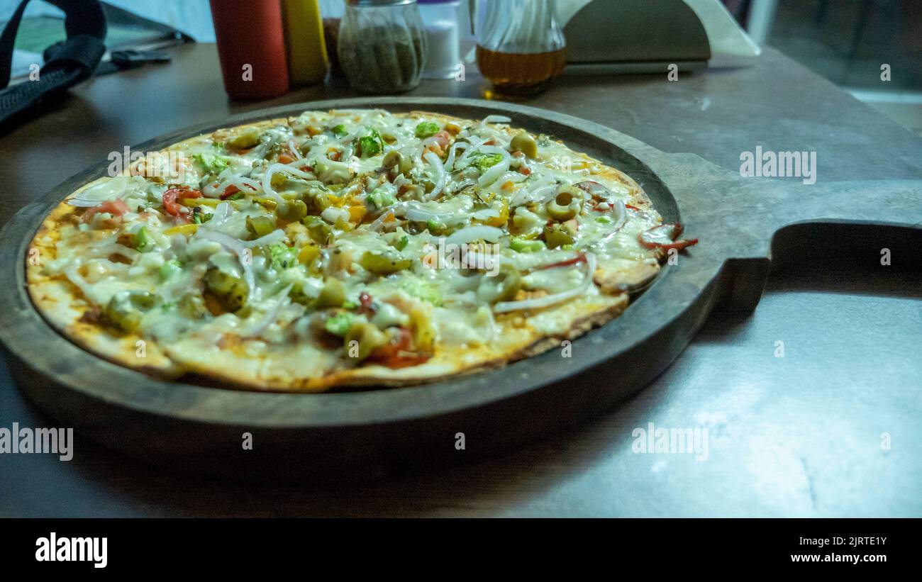 Pizza vegetariana en la india. Pizza de verduras con queso indio. Foto de stock