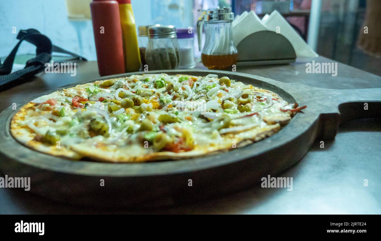 Pizza vegetariana en la india. Pizza de verduras con queso indio. Foto de stock