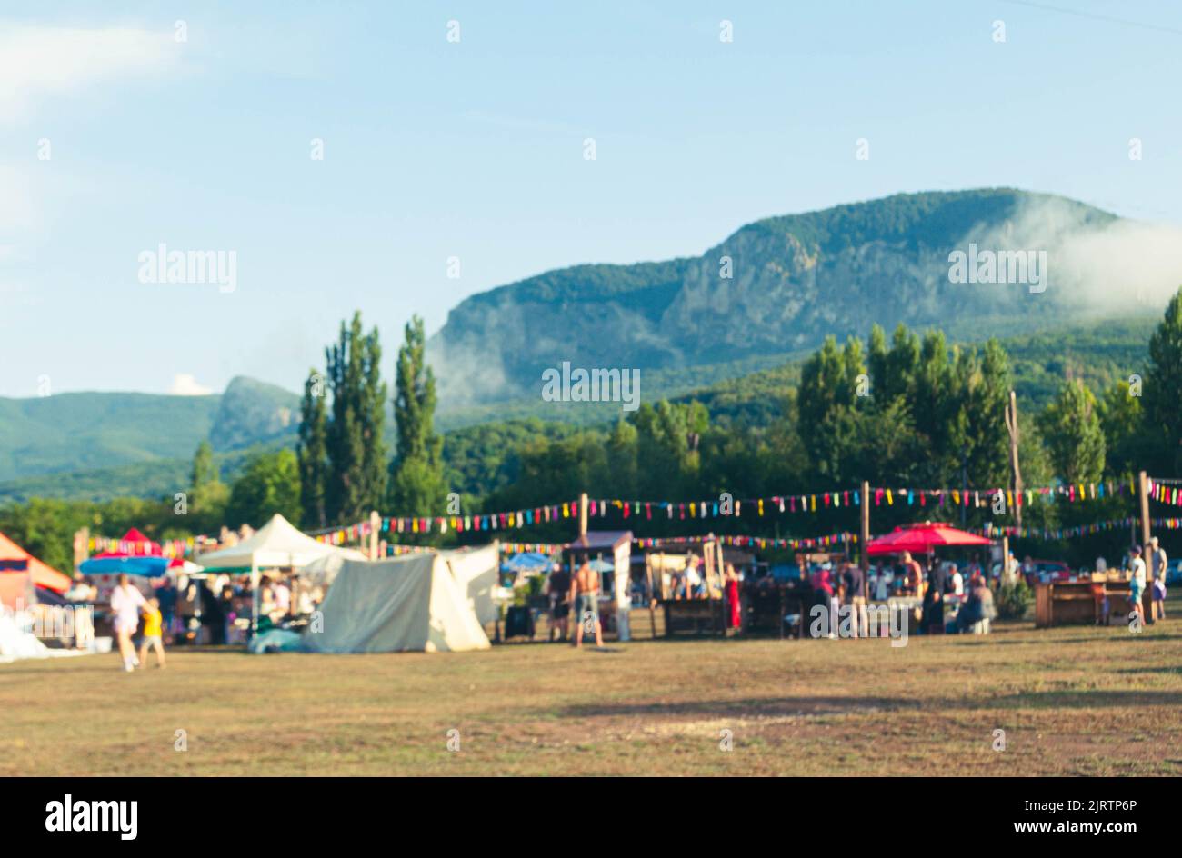 Hermoso bokeh fondo del festival en el campo rodeado de montañas. Foto de stock