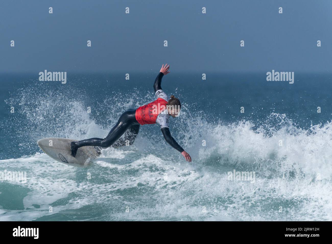 Un surfista masculino que compite en una competición de surf en Fistral en Newquay en Cornwall en el Reino Unido. Foto de stock