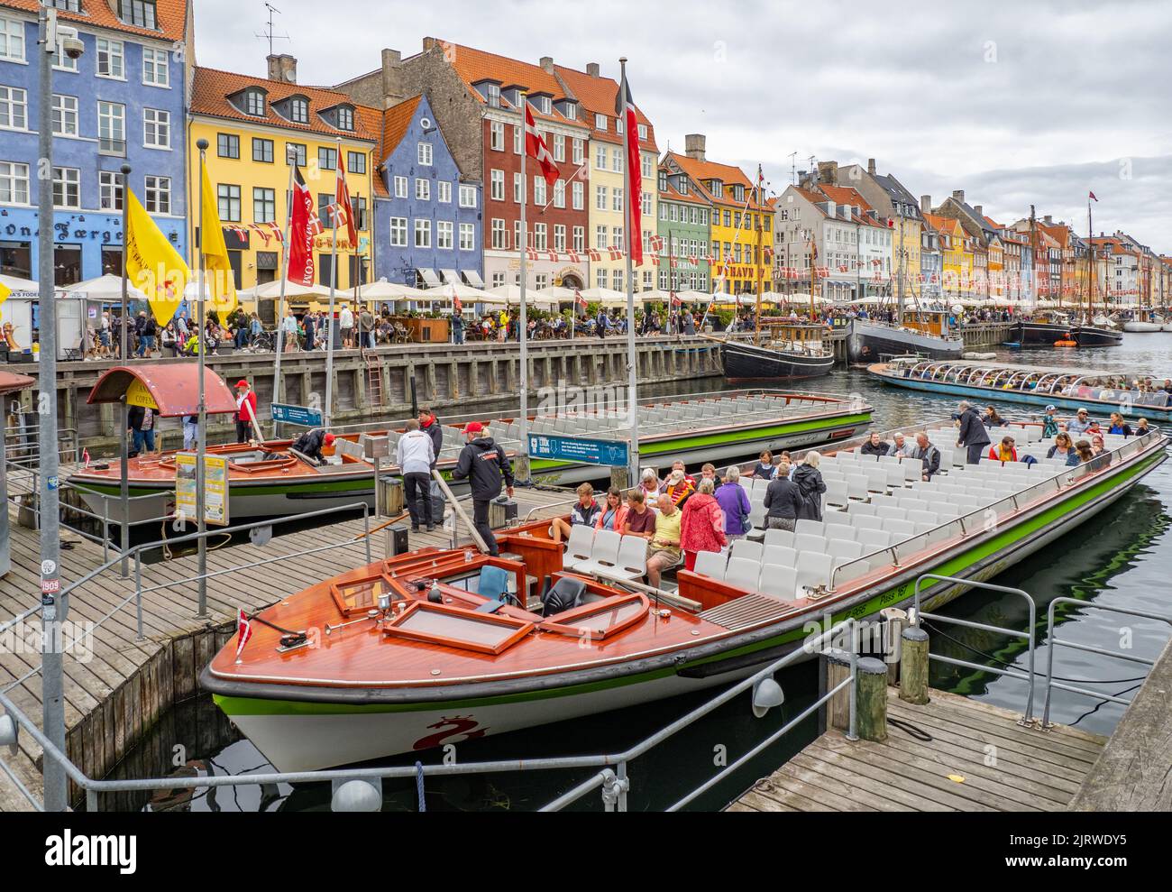 El destino turístico popular de Nyhavn una ensenada del mar bordeada de 17th C casas de colores cafés y bares y barcos de vela - Copenhague Dinamarca Foto de stock