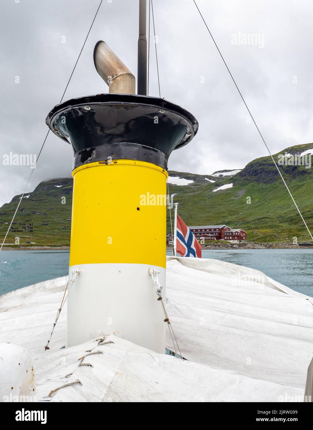 El ferry Bitihorn con su embudo amarillo brillante navegando desde Eidsbugarden hasta Bygdin en el lago Bygdin en el Parque Nacional de Jotunheimen Noruega Foto de stock
