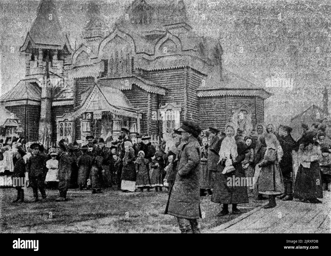 La forma de vida de los colonos. Cerca de la iglesia de vacaciones (en el fondo la iglesia de madera de la protección de la Theotokos en Alexandrovsk-Sakhalinsky, 1903 Foto de stock