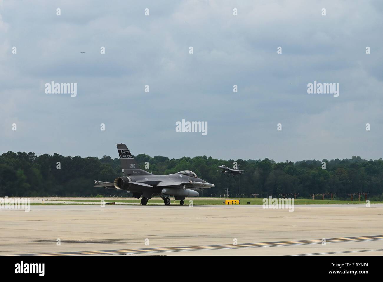 Los aviones de combate F-16 de la Fuerza Aérea de los EE.UU. Asignados al 169th Fighter Wing de la Base Conjunta de la Guardia Nacional McEntire, Carolina del Sur, toquen y regresen en en taxi después de realizar vuelos de entrenamiento rutinarios en el Aeropuerto Metropolitano de Columbia, Carolina del Sur, 24 de agosto de 2022. El 169th Fighter Wing está volando temporalmente fuera del Aeropuerto Metropolitano de Columbia mientras que la pista de aterrizaje de la Base Conjunta de la Guardia Nacional McEntire se encuentra en construcción. (EE. UU Foto de la Guardia Nacional Aérea por Airman 1st Clase Danielle Dawson) Foto de stock
