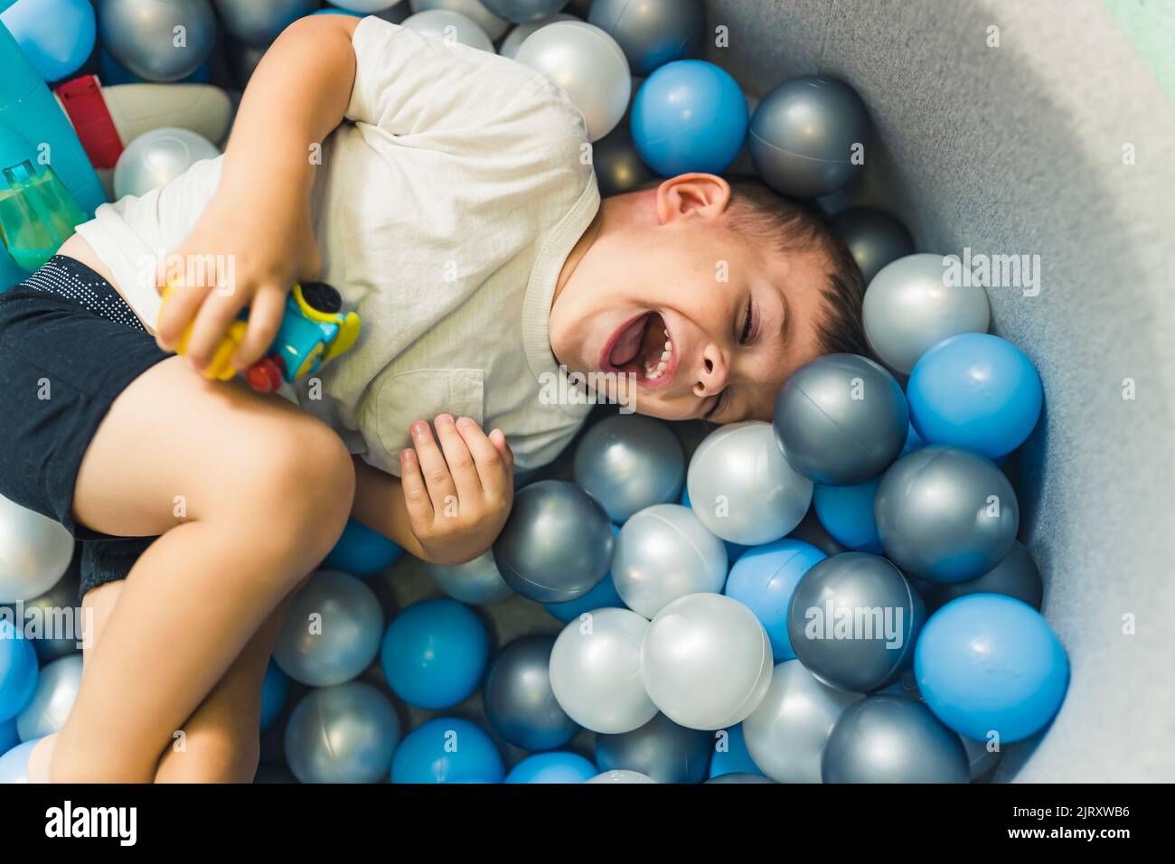 Niño Feliz Jugando En Un Hoyo De Pelota Lleno De Bolas De Colores Juegos Sensoriales En La