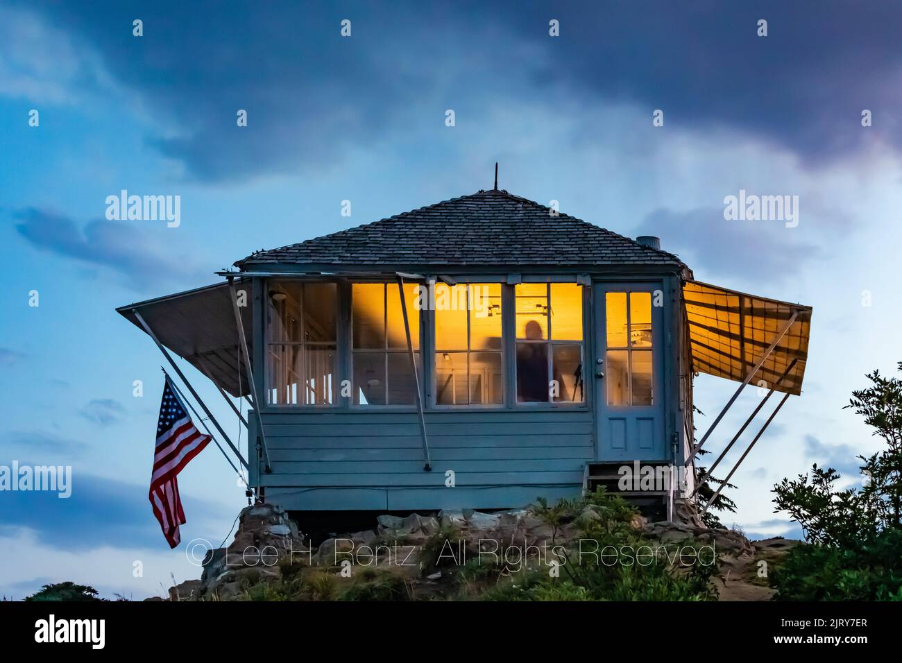 Crepúsculo en Evergreen Mountain Lookout, con visitantes que alquilan el mirador iluminándolo dentro, Mt. Bosque Nacional Baker-Snoqualmie, Washington Stat Foto de stock