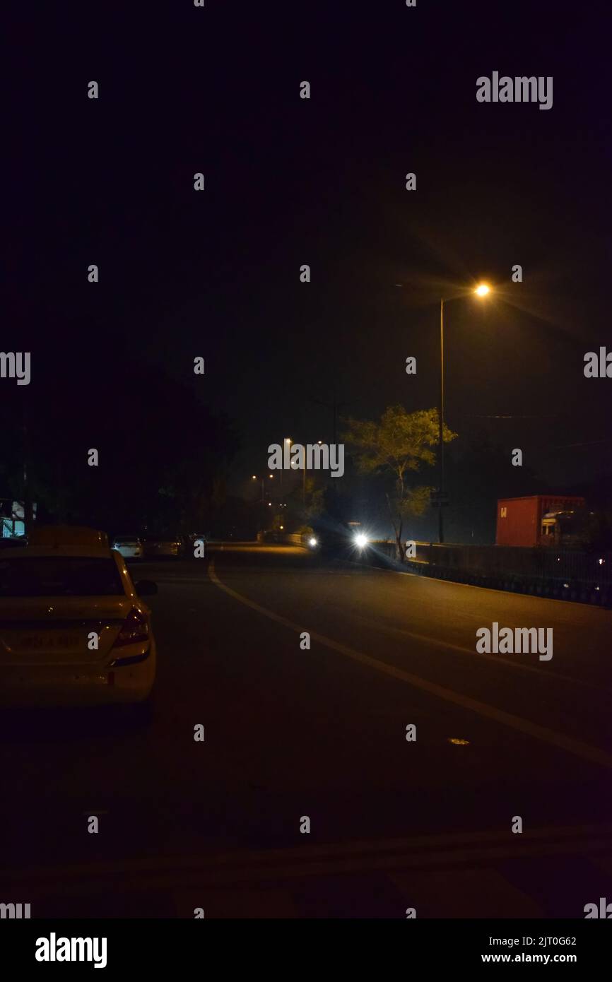 Vista nocturna de una calle vacía en Nueva delhi, India. Foto de stock