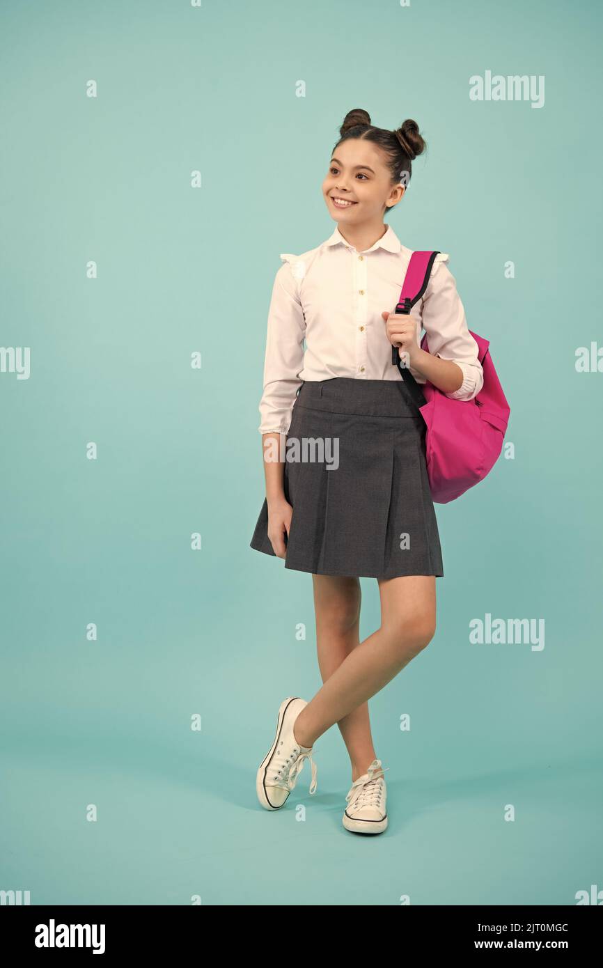 Niña de la escuela en uniforme escolar con mochila escolar adolescente  escolar sostiene mochila sobre fondo amarillo aislado