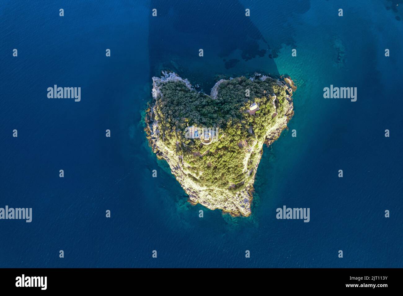 Vista aérea desde arriba de la hermosa isla natural en forma de corazón en el mar Mediterráneo a lo largo de la costa de Liguria, Italia Foto de stock