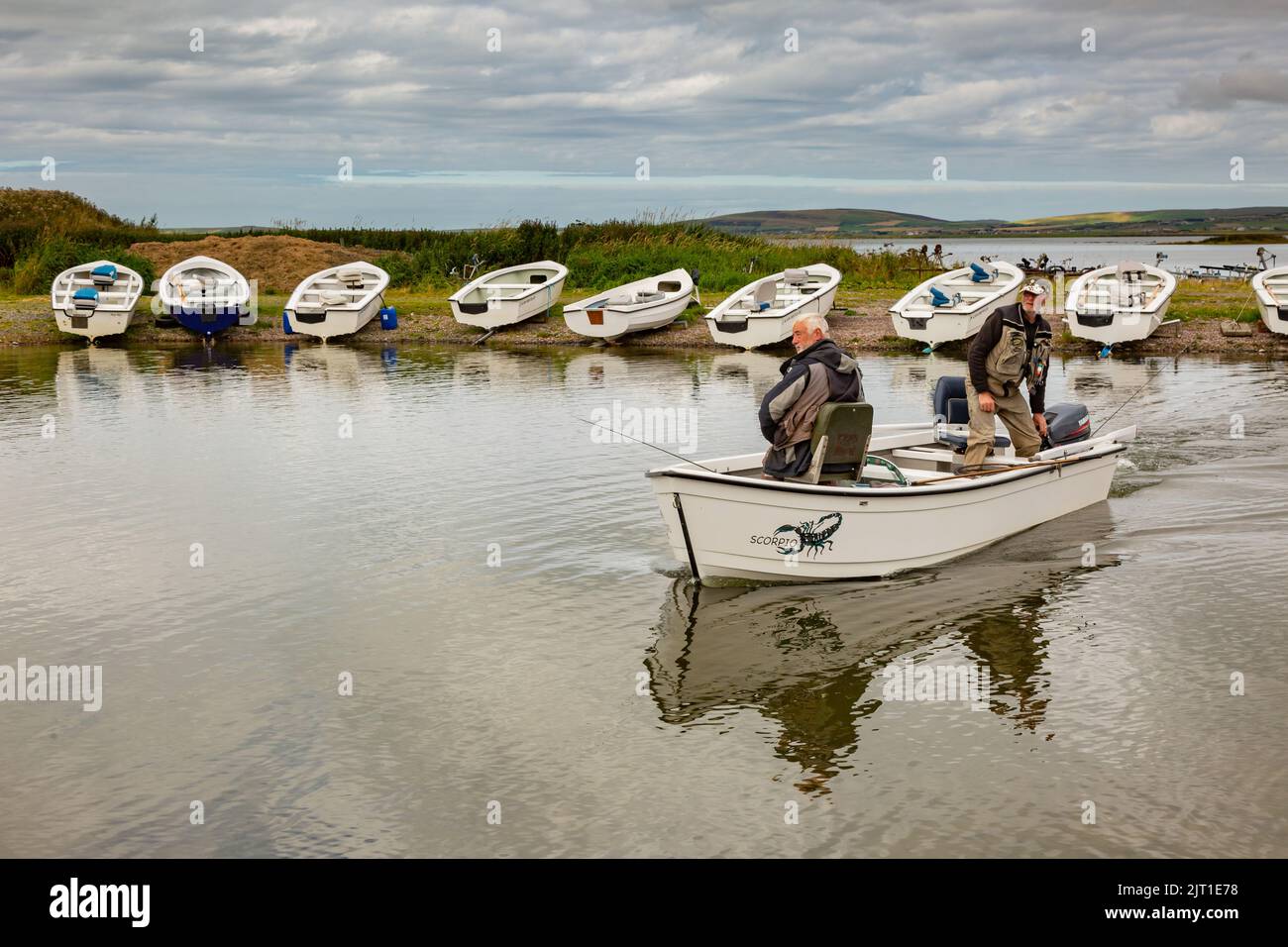 Loch Harray, Orkney, Reino Unido. 27th de Ago de 2022. Los pescadores con mosca que regresan se reflejan en las tranquilas aguas del lago Harray, Orkney continental, Reino Unido. Los pescadores, cuyo premio es la trucha marrón, están en el agua hasta seis horas al día. Crédito: Peter Lopeman/Alamy Live News Foto de stock