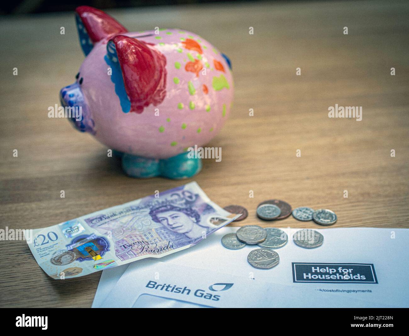 Nota británica de £20 y monedas en la carta del Gobierno de Su Majestad notificando la ayuda del Gobierno del Reino Unido a los hogares, Reino Unido Foto de stock
