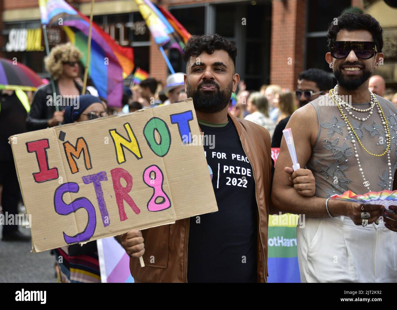 Manchester, Reino Unido. 27th de agosto de 2022. Un hombre lleva un cartel de 'Yo no soy str8'. Los participantes participan en el desfile LGBTQ+ Pride Parade, en el centro de Manchester, Reino Unido, mientras LGBTQ+ Pride continúa durante el fin de semana festivo del 26th al 29th de agosto. Los organizadores dicen: 'Manchester Pride es una de las principales organizaciones benéficas LGBTQ+ del Reino Unido. Nuestra visión es un mundo donde las personas LGBTQ+ son libres de vivir y amar sin prejuicio. Somos parte de un movimiento mundial del Orgullo que celebra la igualdad LGBTQ+ y desafía la discriminación.' Crédito: Terry Waller/Alamy Live News Foto de stock