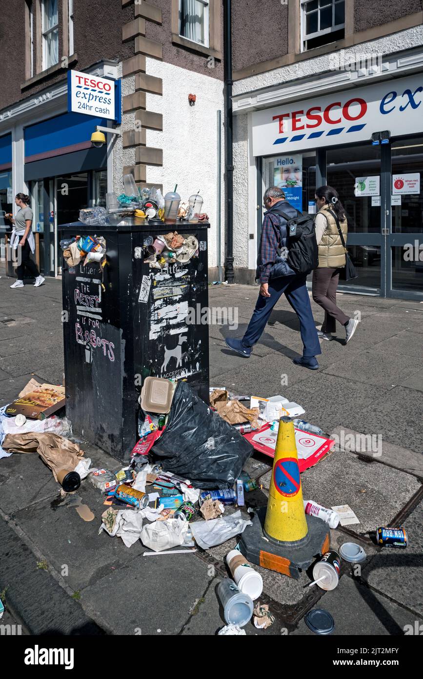 Un contenedor de basura desbordado fuera de una tienda Tesco Express en Nicolson Street debido a la acción industrial de los trabajadores del consejo de Edimburgo. Foto de stock