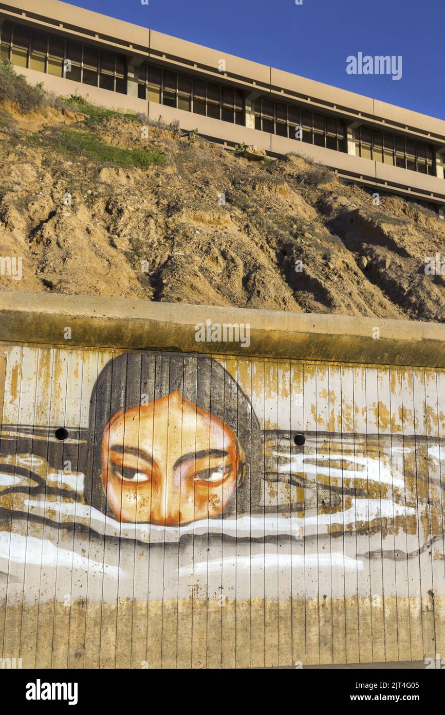 Cara de niña elevándose sobre el océano Graffiti pintado en el Scripps Institute of Ocenography Concrete Wall por Ellen Browning Memorial Pier, San Diego California Foto de stock