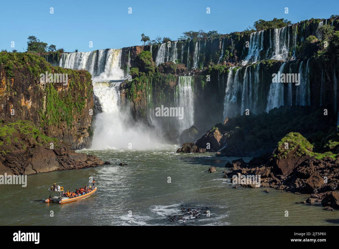 Barco turístico explorando las Cataratas del Iguazú en la frontera entre Argentina y Brasil. Foto de stock