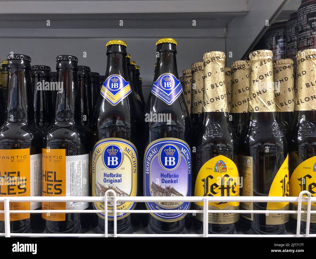 25.08.2022 Ucrania, Kharkiv, estante con cerveza en botellas de vidrio en un supermercado. Cerveza belga de alta calidad Foto de stock