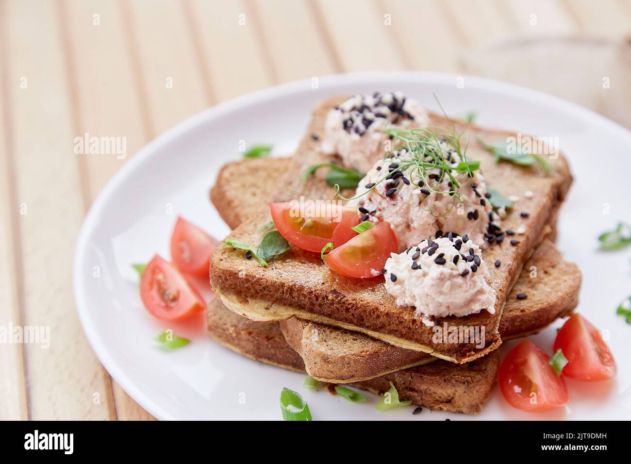Sándwiches de temporada con pan de masa fermentada, tomates, hierbas, quinua y vegano sause. Desayuno vegetariano saludable. Foto de stock
