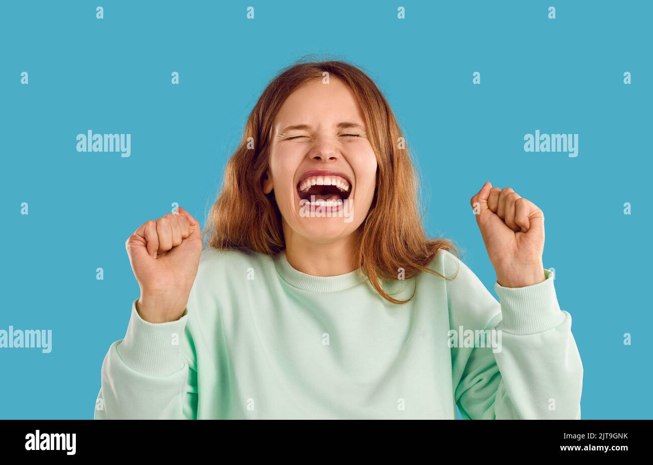 Retrato de mujer joven o adolescente divertida riendo o gritando con la boca abierta Foto de stock