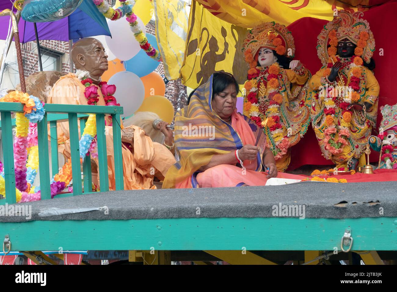 Un devoto adorador Hindú con incienso en sus manos, se sienta en el carro y flotador principal en el 2022 ratha Yatra Parade en Liberty Ave en Queens, New Yor. Foto de stock